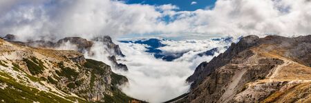Panoramic view of beautiful rocky mountains covered with clouds, Dolomites, Italy