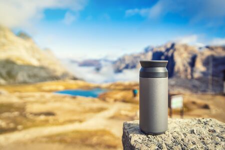 Thermo cup standing on the rock with a view in Dolomites, Italy. Travel and adventure concept.の写真素材