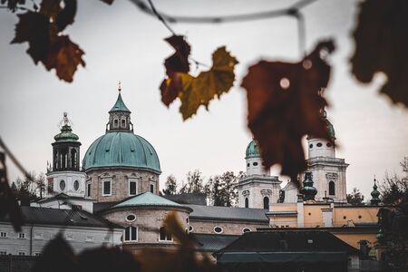 Salzburg Cathedral historical building view framed by autumn foliage, Austria