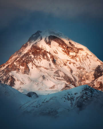 Kazbek mountain peak dramatic view in winter sunrise, Georgiaの素材 [FY310183557287]