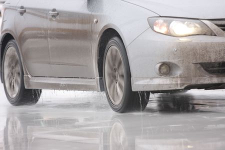 Moving car on ice with water spray