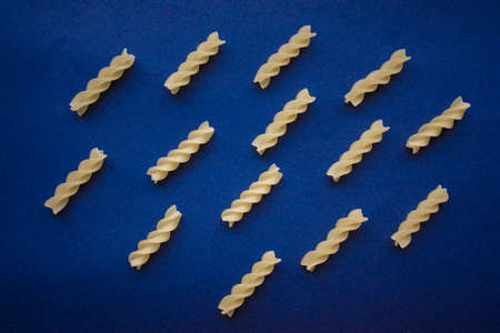 mosaic pasta in the form of a spiral on a blue backgroundの写真素材