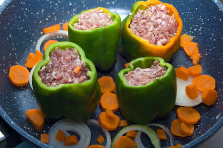 four stuffed with minced pepper with carrot and onion  in a frying pan, top viewの写真素材