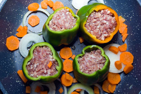 four stuffed with minced pepper with carrot and onion  in a frying pan, top viewの写真素材