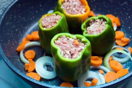 four stuffed with minced pepper with carrot and onion  in a frying pan, top viewの写真素材