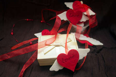 romantic background: box with a gift, a garland of hearts on a dark background. concept for Valentine's day, anniversary, a romantic occasionの写真素材