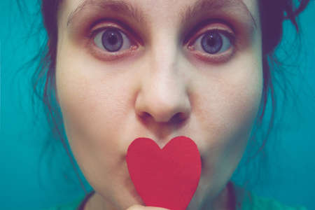 girl with paper  heart in retro colours. concept for Valentine's day, the concept for heart disease.の写真素材