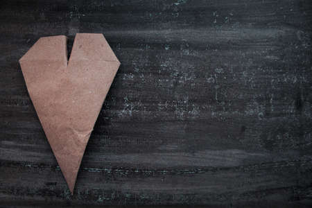 Kraft paper heart on dark wooden backgroundの写真素材