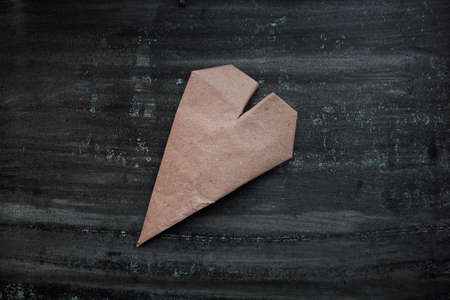 Kraft paper heart on dark wooden backgroundの写真素材