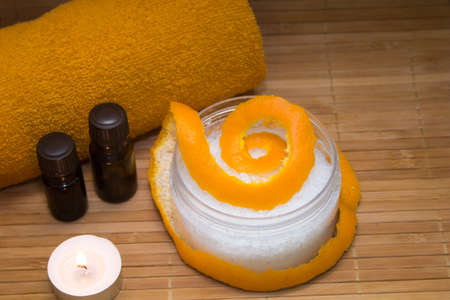 Spa concept.Citrus scrub, towel, aroma oil, citrus peel, on a straw Mat.の写真素材
