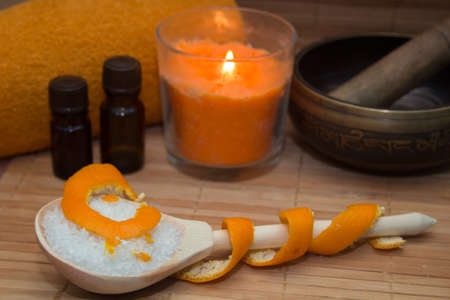 Spa concept.Citrus scrub, towel, aroma oil, peel citrus, the singing bowl on straw Mat.の写真素材