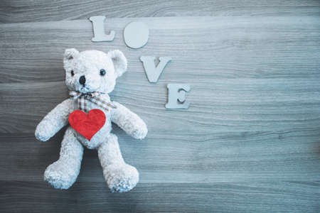 Teddy bear, LOVE letters, heart on wooden background. Place for text. The concept to St. Valentine.の写真素材