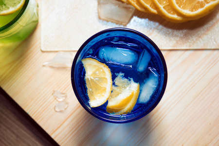 Sparkling water, soda or a gin and tonic in colorful glasses with lemon and ice.Concept for bar menu or detox  with water with lemon.の写真素材