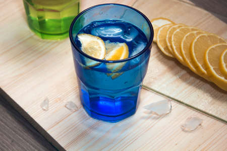 Sparkling water, soda or a gin and tonic in colorful glasses with lemon and ice.Concept for bar menu or detox  with water with lemon.の写真素材