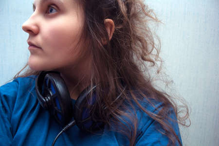 Young girl,white skin, brown hair,sad,brooding with headphones.の写真素材