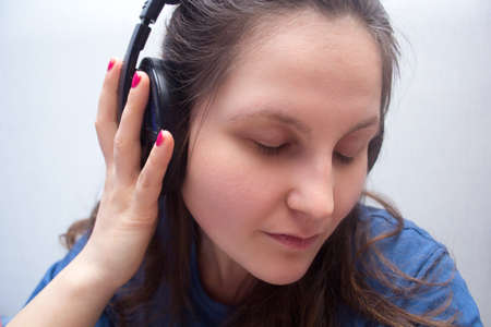 Girl in headphones with eyes closed listening to soothing musicの写真素材