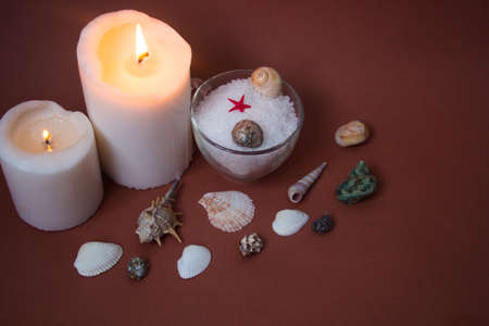 Spa concept. Seashells , candles and  sea salt  on brown backgroundの写真素材