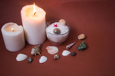 Spa concept. Seashells , candles and  sea salt  on brown backgroundの写真素材