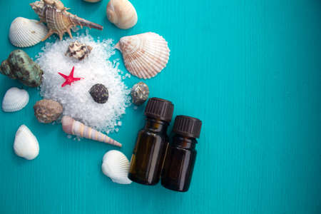 Spa concept. Seashells , aroma oils and  sea salt  on blue wooden backgroundの写真素材