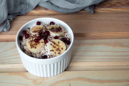 oatmeal with fresh banana slices, cranberries and flax seedの写真素材