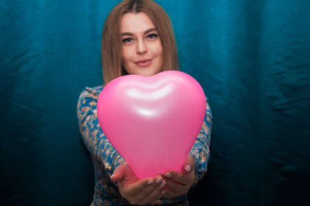 girl with pink heart shaped balloon in handsの写真素材