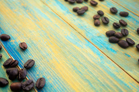 coffee beans on wooden background painted in blue and gold. place for text.の写真素材