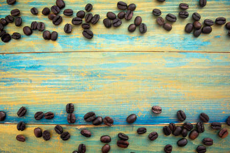 coffee beans on wooden background painted in blue and gold. place for text.の写真素材