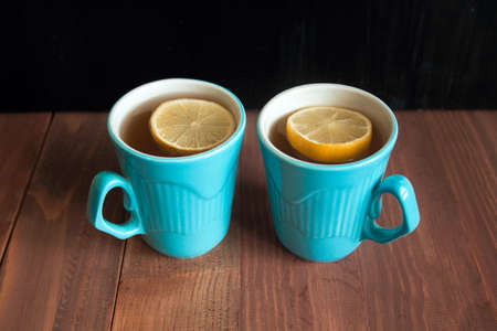 lemon tea in  blue cups on a wooden tableの写真素材