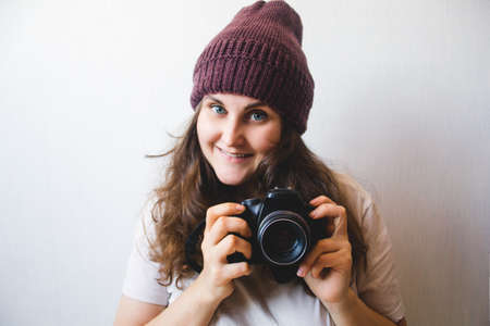 young hipster girl in a white shirt and brown hat with cameraの写真素材