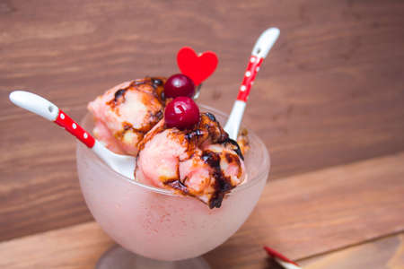 fruit ice cream served with cherries and chocolate syrupの写真素材
