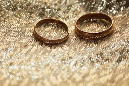 gold wedding rings on a gold cloth backgroundの写真素材