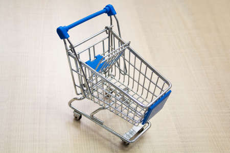 Mini shopping cart / supermarket trolley on a light background