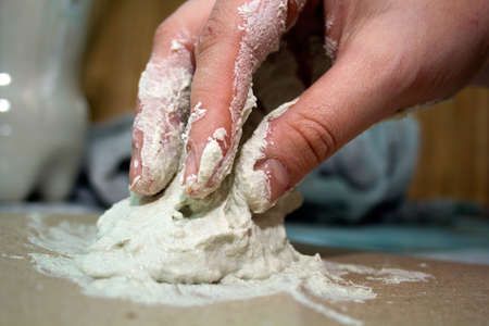 close up hands of ceramist  with white clayの写真素材