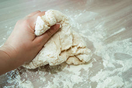 woman kneads  dough by hand