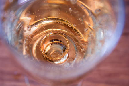 wedding background: Golden rings at the bottom of the glass with champagneの写真素材