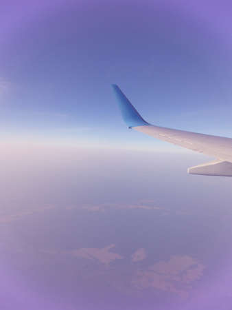 Background with sky and wing of an airplane. Toned. Travel concept.