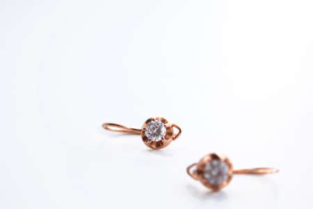 Gold earrings with white gem on white backgroundの写真素材