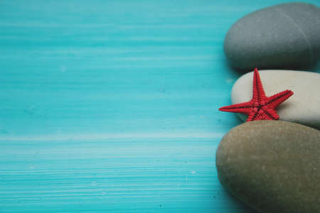 summer blue background with sea pebbles and starfishの写真素材