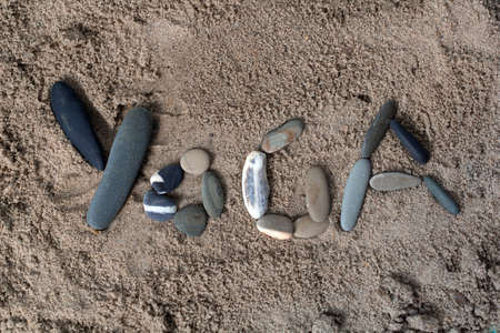 inscription yoga made from stones on the sand.の写真素材