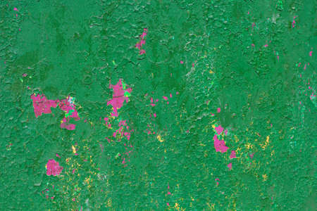 texture of the wall painted a rich green with splashes of pink layer underneathの写真素材