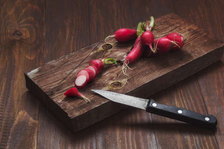 radishes on a wooden cutting Board on a rustic wooden table.の写真素材
