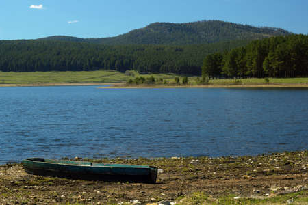 landscape of the Ural mountains, lake and an old boatの写真素材
