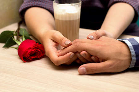 Romantic dating. Male and female hands caressing with love. Couple on  dating at coffee shop.の写真素材
