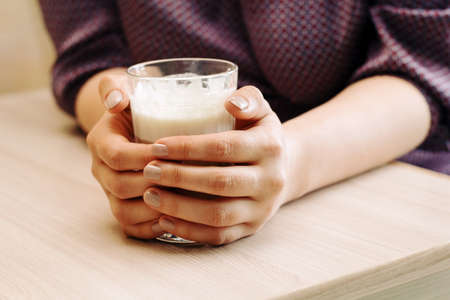 close up female hands in a cafe, hugging a Ñup of hot coffeeの写真素材