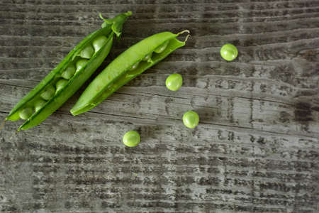 young juicy green peas on a wooden table. copy spaceの写真素材