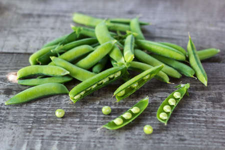 young juicy green peas on a wooden tableの写真素材
