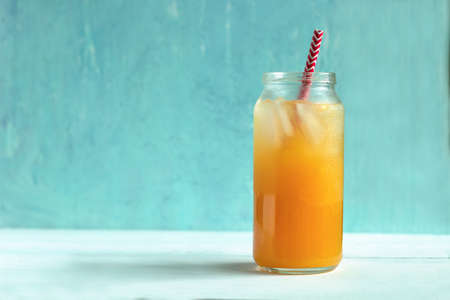 freshly-squeezed orange juice with ice on a pastel blue background.の写真素材