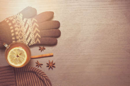 gloves, hat and hot tea with lemon and spices. warm autumn toning. copy space.の写真素材