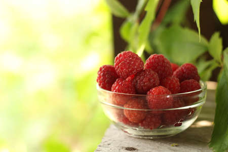 Cup of raspberries in the gazebo in the summer garden