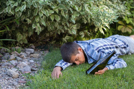 drunk man sleeping in the park after the party. the problem of  alcoholism.の写真素材